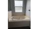 Relaxing soaking tub with window view, set in a tiled bathroom at 1117 Cambourne Dr, Kissimmee, FL 34758