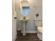 Bathroom featuring pedestal sink, oval mirror, and modern toilet at 1117 Cambourne Dr, Kissimmee, FL 34758