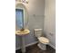 Powder room featuring pedestal sink, oval mirror, and modern toilet at 1117 Cambourne Dr, Kissimmee, FL 34758