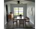 Dining area with a wood table, six chairs, a ceiling fan, and natural light from a window at 1117 Cambourne Dr, Kissimmee, FL 34758