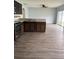 Kitchen with stainless steel appliances, dark wood cabinets, granite countertops, and wood-look flooring at 1117 Cambourne Dr, Kissimmee, FL 34758