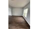 Bright, airy living room with wood-look flooring, light gray walls, and natural light from a large window at 1117 Cambourne Dr, Kissimmee, FL 34758