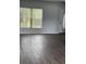 Bright and airy living room featuring wood-look flooring and a front door with decorative glass at 1117 Cambourne Dr, Kissimmee, FL 34758