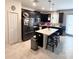 Modern kitchen featuring black cabinetry, stainless steel appliances, and a center island at 11588 Whistling Pine Way, Orlando, FL 32832
