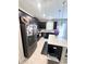 Contemporary kitchen with black cabinets, stainless steel fridge, and white countertops at 11588 Whistling Pine Way, Orlando, FL 32832