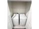 A convenient laundry closet with a stacked washer and dryer set and white shelving at 11588 Whistling Pine Way, Orlando, FL 32832