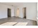 A bright and spacious bedroom boasts wood-look flooring, neutral walls, and ample doorway access at 1209 S Station Pl # 306, Orlando, FL 32809