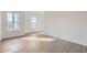 Spacious bedroom featuring wood-look floors, natural light from large windows, and white walls at 1209 S Station Pl # 306, Orlando, FL 32809