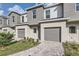 Attractive townhomes showcasing neutral exteriors, private garages, and well-kept lawns at 1209 S Station Pl # 306, Orlando, FL 32809