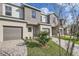 Charming townhome featuring a gray exterior, paved driveway, and manicured landscaping at 1209 S Station Pl # 306, Orlando, FL 32809