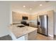 A modern kitchen featuring stainless steel appliances, granite countertops, and light wood cabinets at 1209 S Station Pl # 306, Orlando, FL 32809