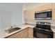 Modern kitchen featuring light wood cabinets, stainless steel appliances, and granite countertops at 1209 S Station Pl # 306, Orlando, FL 32809