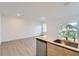 Open living space featuring wood-look flooring, granite countertops, and large windows for natural light at 1209 S Station Pl # 306, Orlando, FL 32809