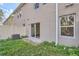Exterior of townhome featuring a sliding glass door, small patio, and small grass backyard at 1217 S Station Pl # 502, Orlando, FL 32809