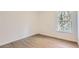 Well-lit bedroom with wood-look flooring and a window looking out to trees at 1217 S Station Pl # 502, Orlando, FL 32809