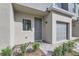 Close up of townhome exterior featuring front door, single car garage, and small landscaped front yard at 1217 S Station Pl # 502, Orlando, FL 32809