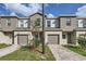 Exterior view of townhome featuring neutral paint, one car garage, and small lawn at 1217 S Station Pl # 502, Orlando, FL 32809