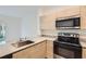 Close-up of kitchen features stainless steel oven and cooktop, stone countertop and wood cabinets at 1217 S Station Pl # 502, Orlando, FL 32809