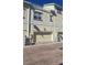 Exterior of a tan two-story townhome featuring a one-car garage, brick paver driveway and a rooftop deck at 136 Mcleods Way, Winter Springs, FL 32708