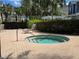 A luxurious hot tub with clear water is nestled within a brick-paved patio and surrounded by lush greenery at 136 Mcleods Way, Winter Springs, FL 32708