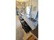 Granite kitchen island with bar seating, sink, and stylish pendant lights, with a dining area visible at 136 Mcleods Way, Winter Springs, FL 32708
