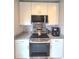 Close up of modern kitchen with stainless steel appliances, granite counters, and white cabinets at 136 Mcleods Way, Winter Springs, FL 32708