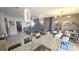 Open-concept living space with gray sofa, stylish lighting, and view of kitchen with granite countertops at 136 Mcleods Way, Winter Springs, FL 32708