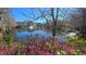 Scenic view of a pond with a fountain surrounded by pink azaleas and natural landscaping at 136 Mcleods Way, Winter Springs, FL 32708