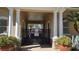 Gated entrance to the pool area, framed by columns and planters, showcasing security and lush surroundings at 136 Mcleods Way, Winter Springs, FL 32708