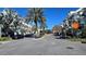 Neighborhood street showcasing parked cars and manicured landscaping under a clear blue sky with palms and shade trees at 136 Mcleods Way, Winter Springs, FL 32708