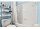 Bright bathroom featuring a tiled shower-tub, storage shelves, and a comfort height toilet at 140 Coco Plum, Davenport, FL 33897