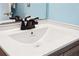 Modern bathroom vanity featuring a new faucet, bright white sink, and woodgrain cabinets at 140 Coco Plum, Davenport, FL 33897