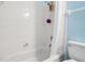White tiled shower and bath with shower curtain and updated faucet at 140 Coco Plum, Davenport, FL 33897
