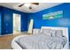 Stylish bedroom with blue accent wall, unique bed frame, and ensuite bathroom access at 140 Coco Plum, Davenport, FL 33897