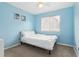 Bright bedroom with a window, a comfortable bed, and blue walls at 140 Coco Plum, Davenport, FL 33897
