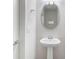 A half bath showcasing a pedestal sink, modern lighting, and simple elegant design at 14218 Lanikai Beach Dr, Orlando, FL 32827