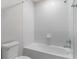 Clean bathroom featuring white tiled shower and tub combo, white toilet, and chrome fixtures at 14218 Lanikai Beach Dr, Orlando, FL 32827