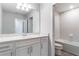 Bright bathroom showcases white cabinetry, quartz countertops, large mirror, and tiled shower/tub combo at 14218 Lanikai Beach Dr, Orlando, FL 32827