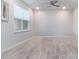 Bright bedroom featuring stylish wood-look flooring, a modern ceiling fan, and a large window at 14218 Lanikai Beach Dr, Orlando, FL 32827