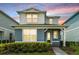 Charming two-story home with a covered entry and lush landscaping at sunset at 14218 Lanikai Beach Dr, Orlando, FL 32827