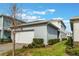 Detached one-car garage with a white door and brick paver driveway and green lawn at 14218 Lanikai Beach Dr, Orlando, FL 32827