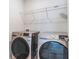 Modern laundry room featuring side by side stainless steel washer and dryer set and wire shelving at 14218 Lanikai Beach Dr, Orlando, FL 32827