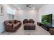 Modern living room with leather furniture, ceiling fan, and laminate flooring at 14218 Lanikai Beach Dr, Orlando, FL 32827