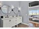 Bright bathroom with dual sinks, quartz countertops, black faucets and round mirrors at 15245 Blue Peacock Ln, Winter Garden, FL 34787
