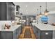 Contemporary kitchen featuring gray cabinetry, stainless steel appliances, large island, and pendant lighting at 15245 Blue Peacock Ln, Winter Garden, FL 34787