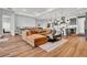 Open-concept living area with hardwood floors, modern furnishings, and seamless flow to kitchen and dining area at 15245 Blue Peacock Ln, Winter Garden, FL 34787