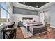 Spacious bedroom with a large bed, tray ceiling, barn door to bath and lots of natural light at 15245 Blue Peacock Ln, Winter Garden, FL 34787