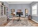 Serene office with gray walls, wood floors, patterned rug, a large wood desk, and a curio cabinet at 15245 Blue Peacock Ln, Winter Garden, FL 34787