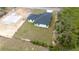 Angled aerial of new construction home featuring a black roof, white walls, and fresh driveway on expansive lot at 16890 Sw 39Th Cir, Ocala, FL 34473