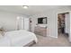 Spacious bedroom featuring carpet floors, neutral walls, TV, walk-in closet, and entry to the bathroom at 2052 Milkweed St, Ocoee, FL 34761